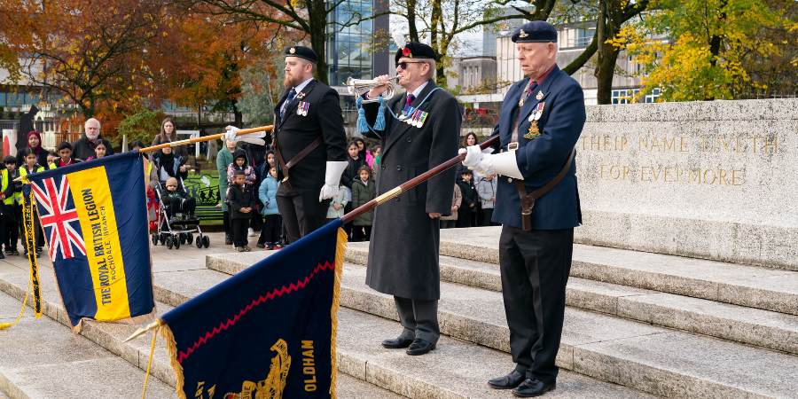 Veterans with lowered flags at Rochdale Cenotaph.