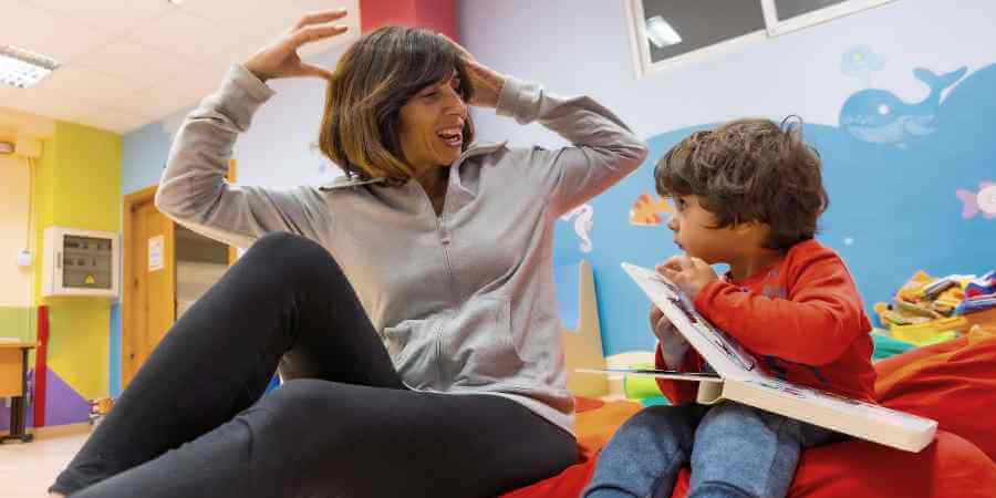 Childminder with child in a library.