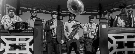 Flat Cap Brass posing with instruments.