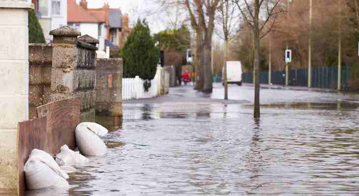 A flooded street with sandbags protecting each gate,