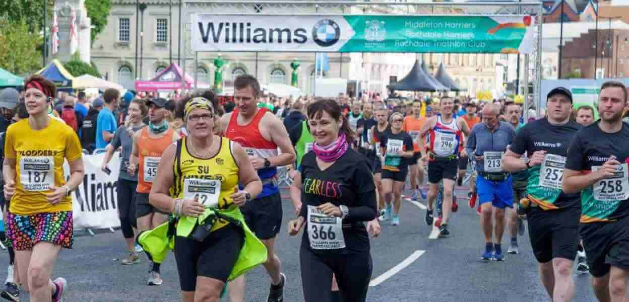 Runners departing from the Half Marathon start line.