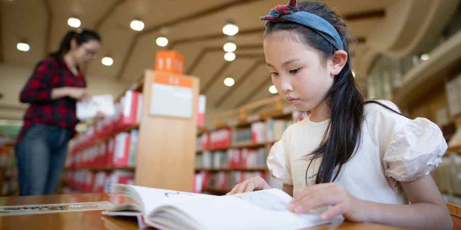 A child doing homework in the library.