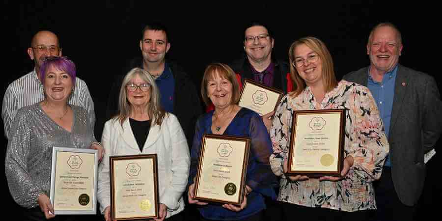 Colleagues with award certificates.