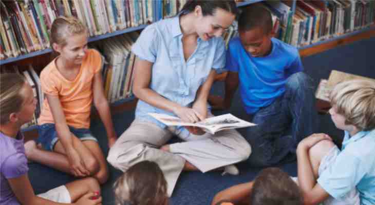 Children listening to a teacher reading a story.