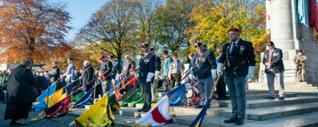 Veterans standing with lowered flags at the Rochdale Cenotaph.