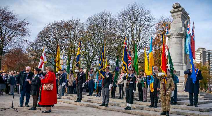 Councillor Neil Emmott at the Rochdale Cenotaph with veterans holding flags.
