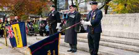 Veterans with lowered flags at Rochdale Cenotaph.