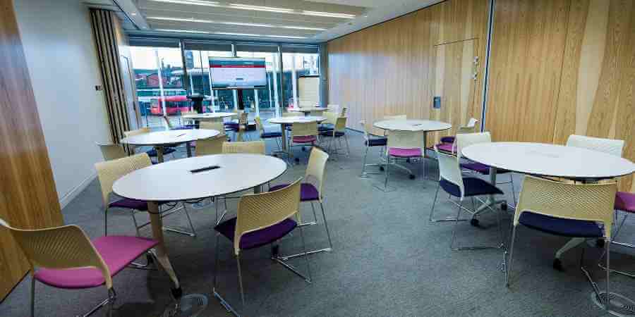 Meeting room with tables set out for a meeting.