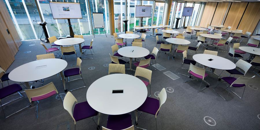 Meeting room set up with circular tables and chairs.