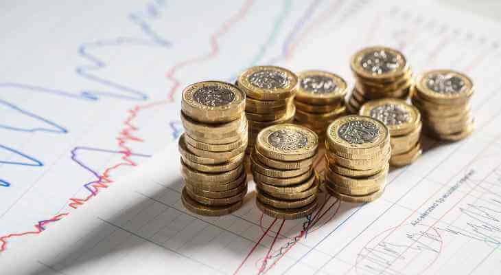 Stacks of coins on financial graph paper.