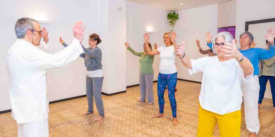 An indoors Tai Chi class with several participants.