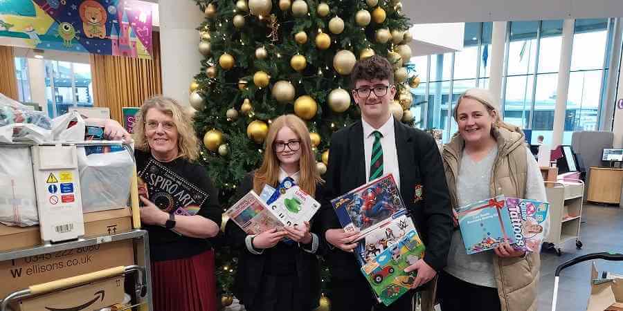 Helen Walton with Lucy and Oliver, all holding donated gifts, at the R and R Therapy salon in Middleton.