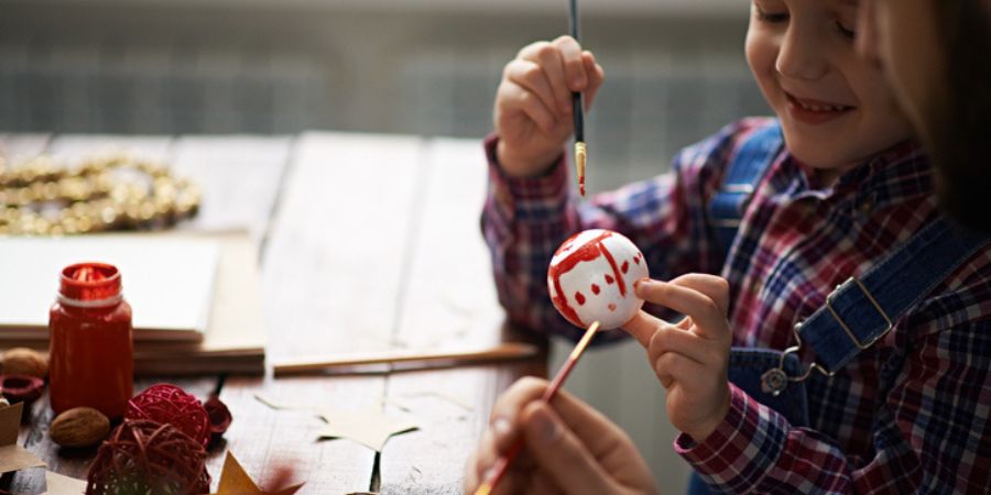 A child decorating a bauble.