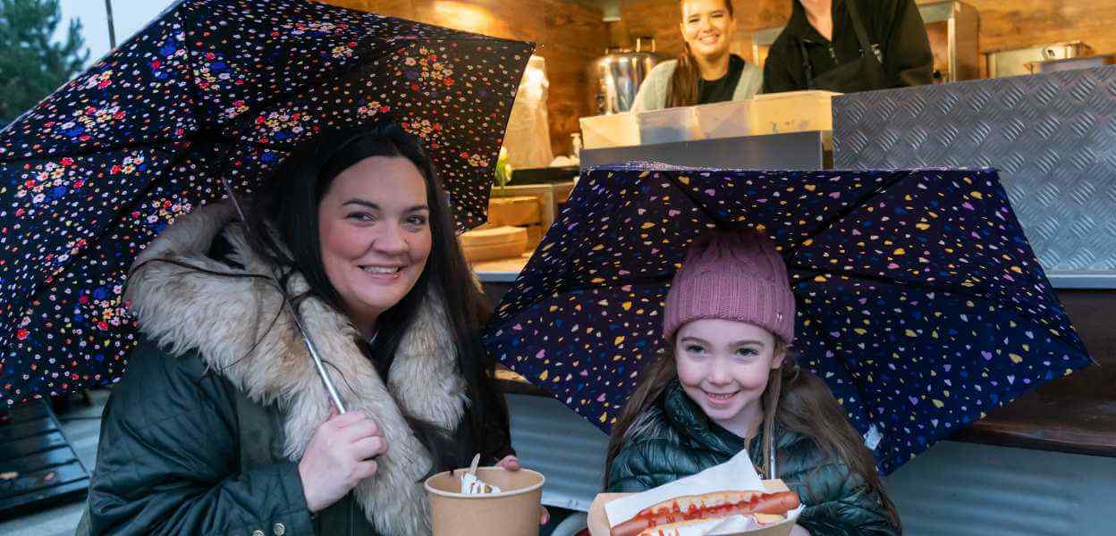 Visitors to a Christmas event at a food truck.