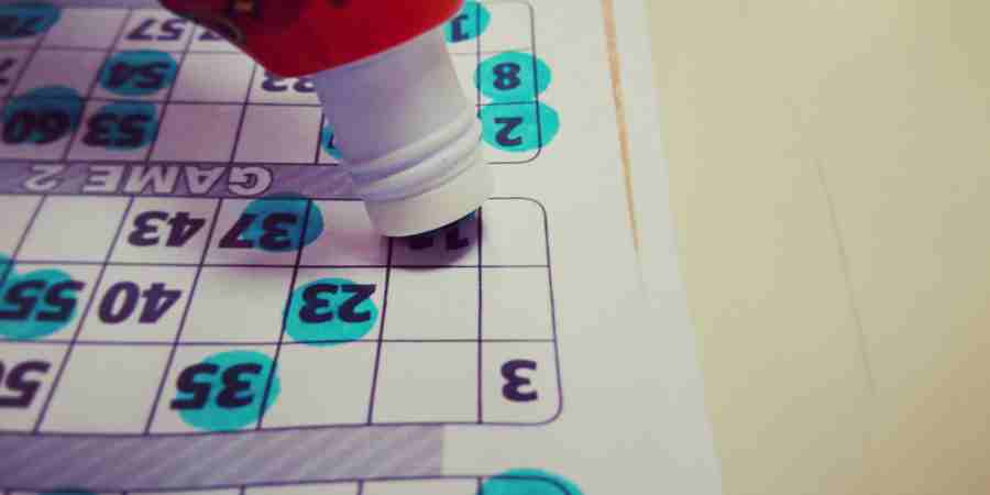 Dabber blotting out numbers on a bingo sheet.