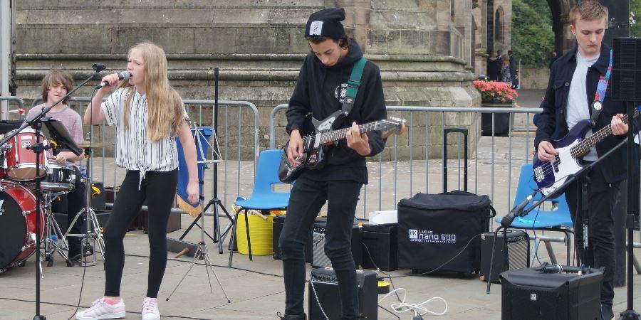A Rock School band performing in front of Rochdale Town Hall.