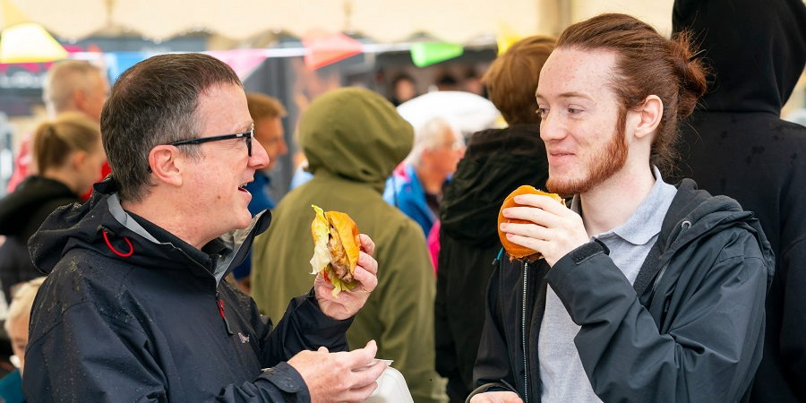 2 visitors to Street Eat, holding burgers.